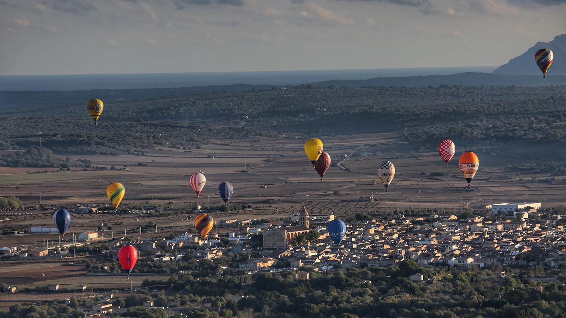 Hot air balloons flying over Manacor town Mallorca incredible spectacular view min